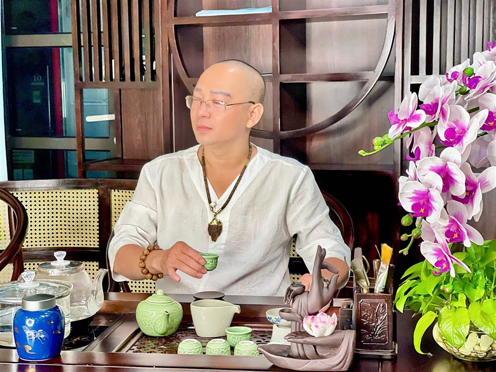 Tiến Tuân cầm tách trà